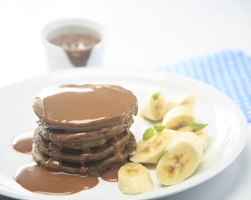 Stack of double chocolate pancakes under a ganache