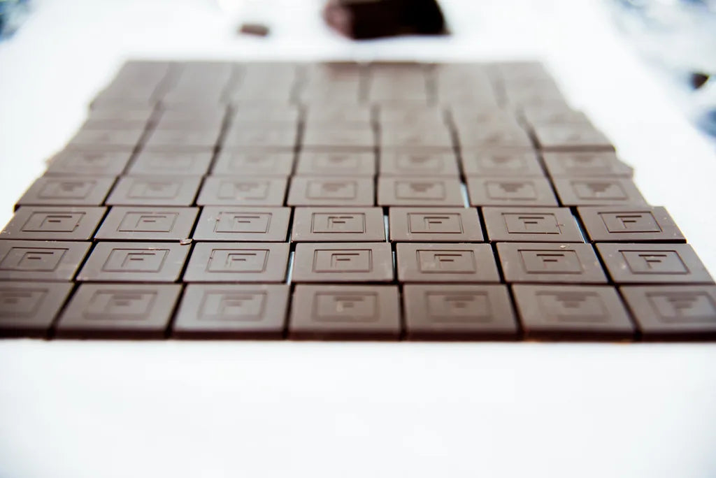 Rows of molded dark chocolate bars, each stamped with the Franceschi F