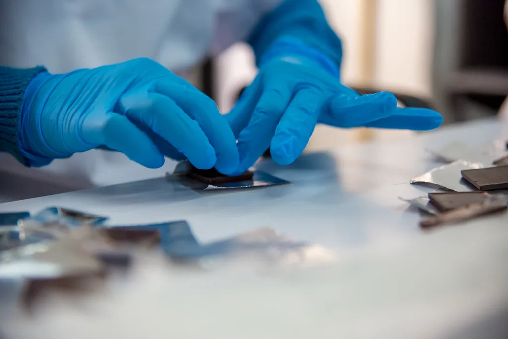 Gloved hands wrapping a chocolate bar in foil