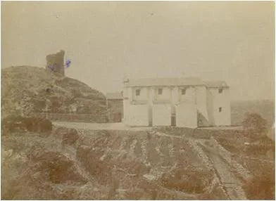 Old sepia photograph of a white house on a hillside